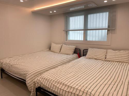 two beds sitting next to each other in a bedroom at 스테이 무드인 in Seoul