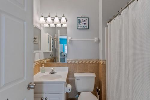 ein Badezimmer mit Toilette, Waschbecken und Spiegel in der Unterkunft 403 E 18Th Ave, Unit 4B in North Wildwood