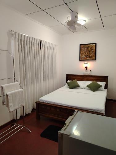 a bedroom with a bed and a window at Villa Green Garden in Hikkaduwa