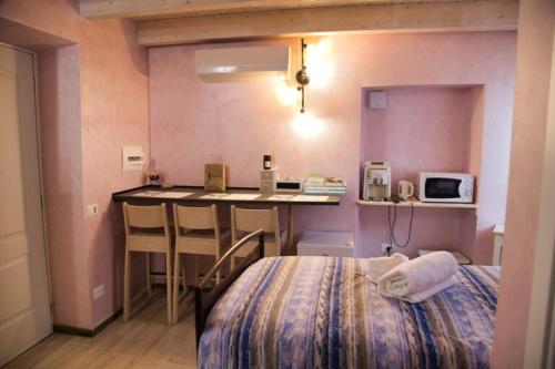 a room with a bed and a table with a microwave at Agriturismo Nonni Devia in Lucinasco