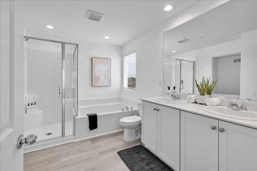 a white bathroom with a toilet and a shower at Oh la la Coachella in Coachella
