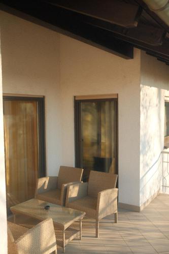 een patio met stoelen, een tafel en een bank bij Pension Zum Waldrand in Sinsheim