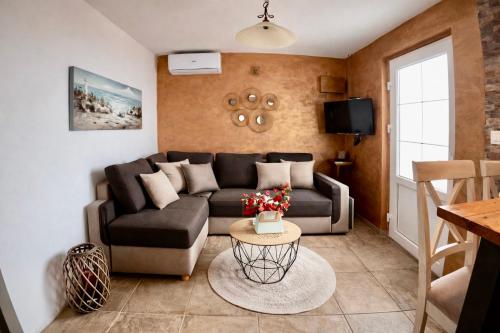 ein Wohnzimmer mit Sofa und Tisch in der Unterkunft Apartments Obradovic in Krasići