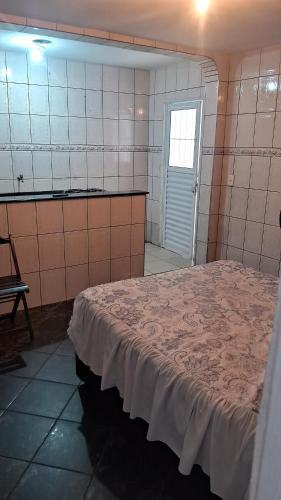 een slaapkamer met een bed in een kamer met een raam bij Casa kitnet in Guarulhos
