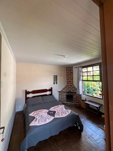 een slaapkamer met een bed en een open haard bij Pousada Taquaral in Bocaina de Minas
