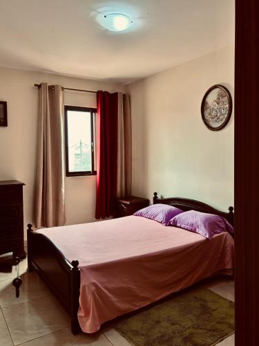 una camera da letto con un letto e un orologio sul muro di Ferreira e Brito apartamentos a Espargos