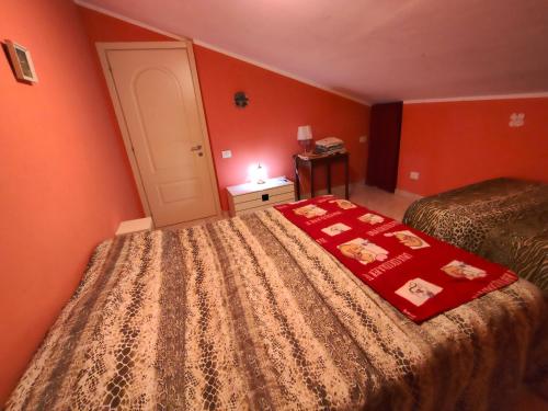 een slaapkamer met twee bedden met oranje muren bij domus rosada in Ripa Teatina