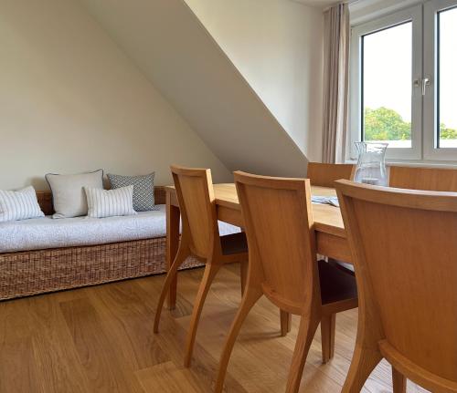 een eetkamer met een tafel en een bank bij Lichtdurchflutete Dachgeschosswohnung in Uninähe in Oldenburg