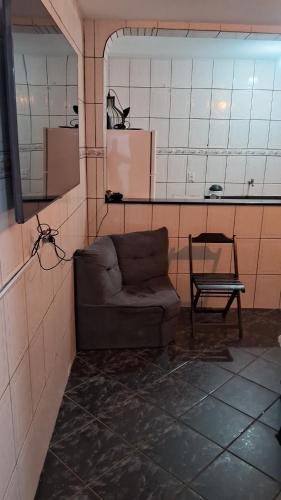Zimmer mit Sofa, Stuhl und Spiegel in der Unterkunft lar doce lar hospedaria 1 in Guarulhos