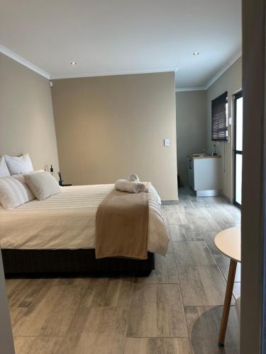 a bedroom with a large bed and a table at Guesthouse Le Michele in Swakopmund