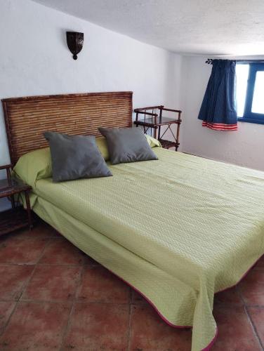 een groot bed in een slaapkamer met een groene sprei bij Paradise Of Aouchtame in Aouchtame