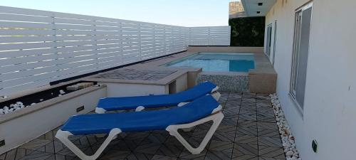 een patio met 2 stoelen en een zwembad bij Interlace penthouse with swimming pool in Il-Ħamrija