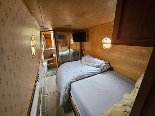 a small bedroom with two beds in a small room at Komet Canal Boats in Nantwich