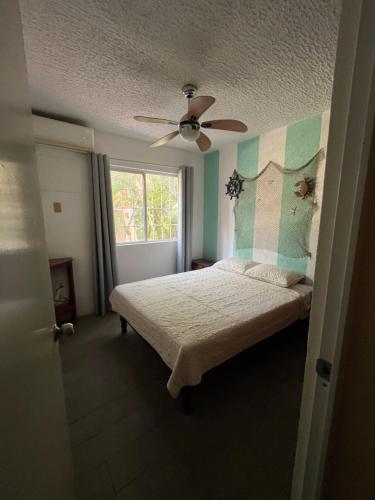 ein Schlafzimmer mit Bett und Deckenventilator in der Unterkunft Raya apartment in Ixtapa