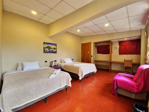 une chambre d'hôtel avec deux lits et une chaise dans l'établissement Casa de Alondras, à Panajachel