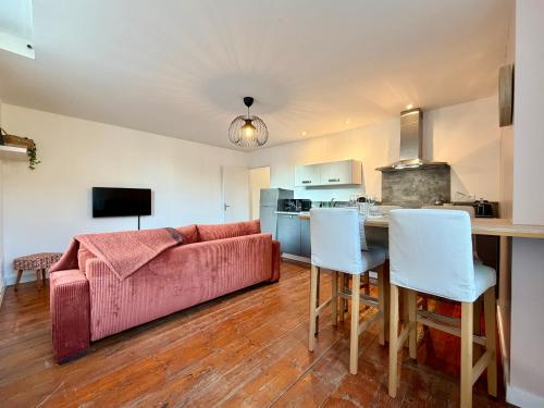 een woonkamer met een roze bank en een tafel bij Rive Gauche in La Celle-sous-Gouzon