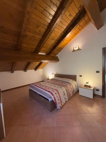a bedroom with a bed and a wooden ceiling at Al Cacciatore in Gallio