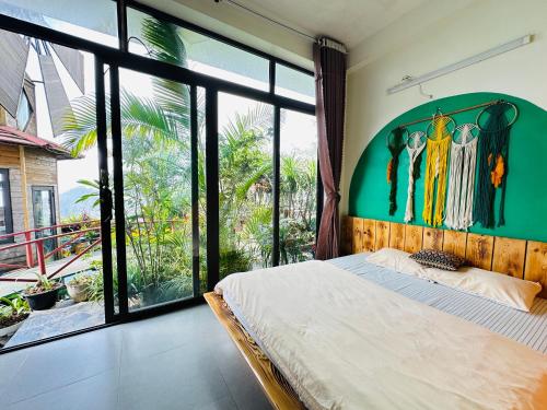 a bedroom with a bed and a large window at Sa Mộc House - Tam Đảo căn Mộc 6 phòng ngủ in Tam Ðảo