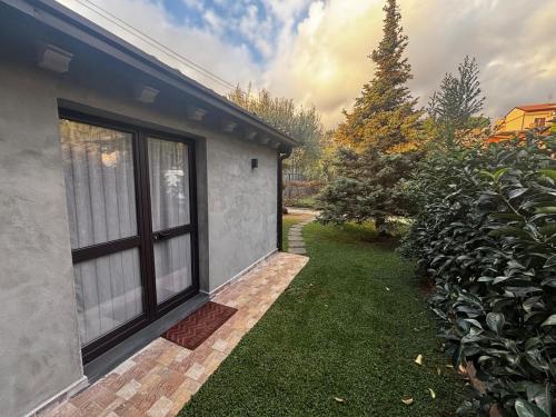 una casa con una finestra accanto a un cortile di La Casetta dei Fiori sull Etna a Ragalna