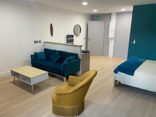 een woonkamer met een blauwe bank en een bed bij Chambre atypique in Domène