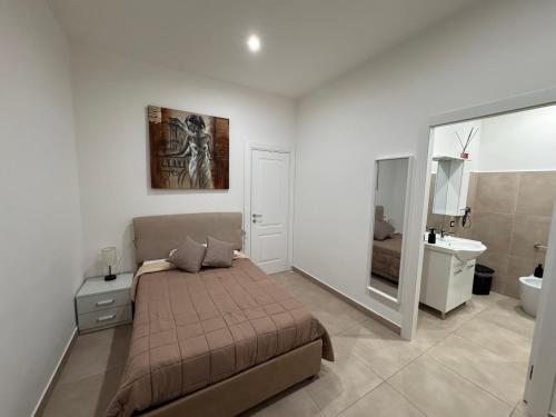 a bedroom with a bed and a bathroom with a sink at Umberto Home 303 in Catania