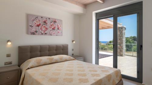 una camera da letto con un letto e una porta scorrevole in vetro di Lindos Summer Memories Villas a Líndos