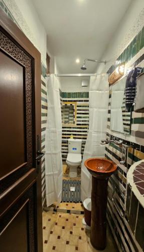 a bathroom with a toilet and a sink and a door at Dar Karaouyine Panoramic in Fez