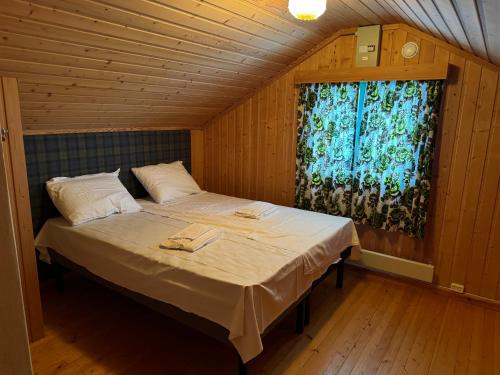 een groot bed in een kamer met een raam bij A comfy House in Hol