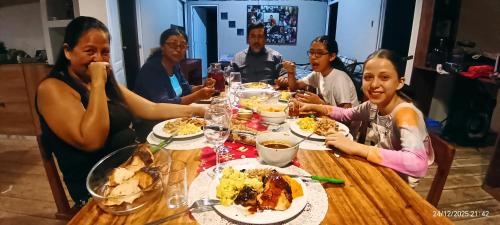 een groep mensen die rond een tafel zitten en eten bij Hacienda & Reserva Monterrico in Romilda