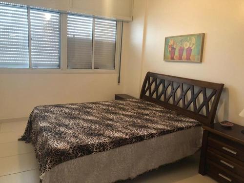 une chambre avec un grand lit et une fenêtre dans l'établissement Pitangueiras Apartment, great location, oceanfront, à Guarujá