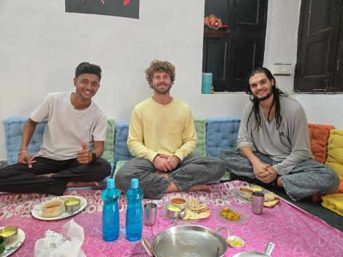 a group of three men sitting on a couch at Green Olive GoStays Best Dormitory and Rooms in Lucknow in Lucknow