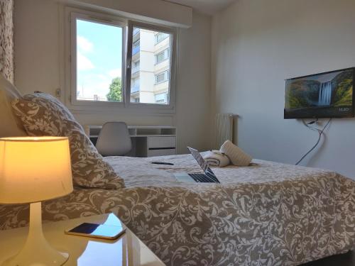 une chambre avec un lit avec un ordinateur portable dessus dans l'établissement Appart'HomeCity - Rouen Grand Prieuré - 1 à 3 chambres, à Rouen