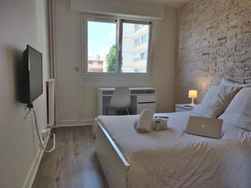 une chambre avec un lit avec un ordinateur portable dessus dans l'établissement Appart'HomeCity - Rouen Grand Prieuré - 1 à 3 chambres, à Rouen