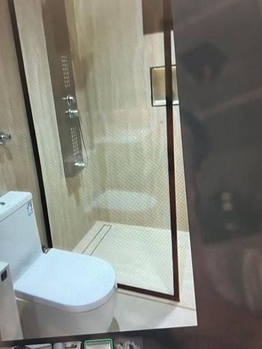 a bathroom with a toilet and a glass shower at جده شارع صاري in Jeddah