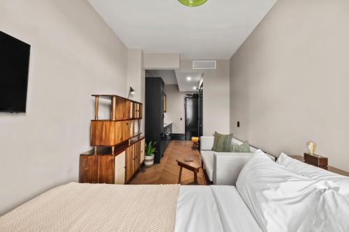 un soggiorno con divano bianco e un soggiorno con divano. di Freeman 602 by Rove - Condo with Shared Amenities a New York