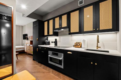 una cucina con armadi neri e lavandino di Freeman 602 by Rove - Condo with Shared Amenities a New York