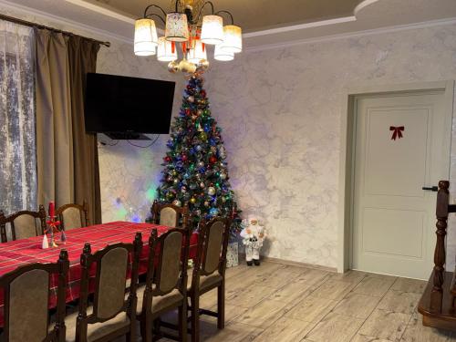 een kerstboom in een eetkamer met een tafel bij U Troh Brativ in Plavie