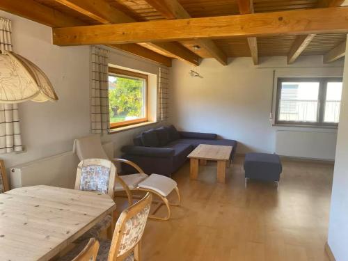 a living room with a blue couch and a table at Ferienhaus Wolfurt in Wolfurt