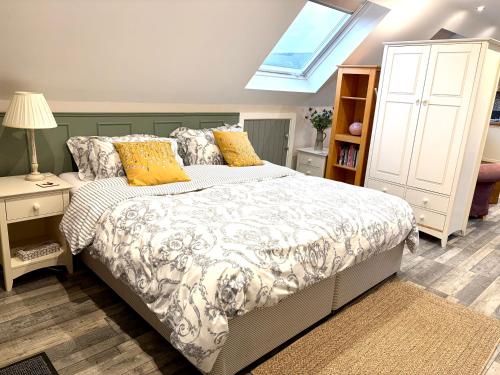 a bedroom with a bed with yellow pillows and a window at The Honeysuckle Coop in Grantham