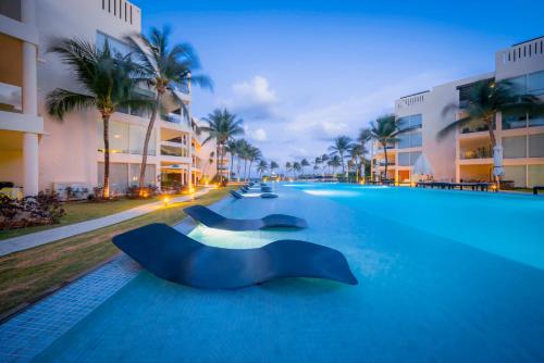 a swimming pool at a resort at night at Ocean View Condo - 2 Bedrooms - at The Elements Condos - Castillo de Arena in Playa del Carmen