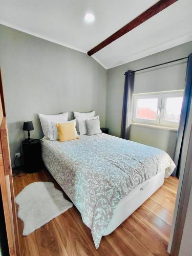 een slaapkamer met een groot bed en een raam bij Tree House III in Setúbal