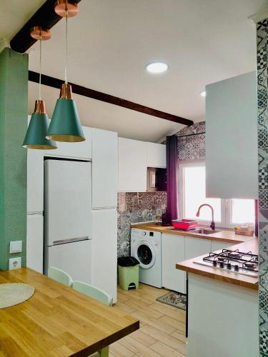 a kitchen with white cabinets and a stove top oven at Tree House III in Setúbal