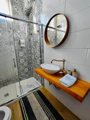 een badkamer met wastafel en douche met spiegel bij Tree House III in Setúbal