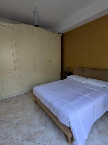 a bedroom with a large bed with white sheets at Casa Migliore - con garage privato in Scicli