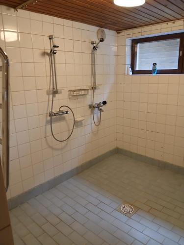 a shower in a tiled bathroom with a window at Gasthause in Rautjärvi