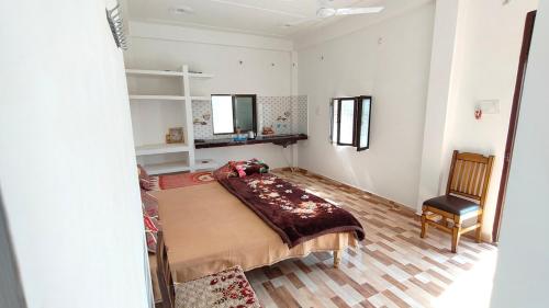 a bedroom with a bed and a chair in it at Ajay homestay &PG in Jhūsi