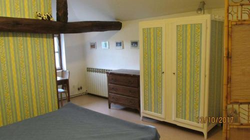 - une chambre avec une commode, un lit et une armoire dans l'établissement La vache sur le toit, à Montagny