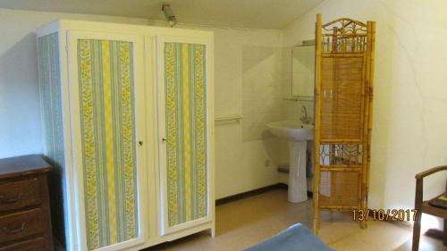 La salle de bains est pourvue d'une armoire blanche et d'un lavabo. dans l'établissement La vache sur le toit, à Montagny