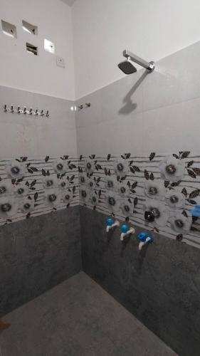 a bathroom with a bunch of birds on the wall at Ajay homestay &PG in Jhūsi