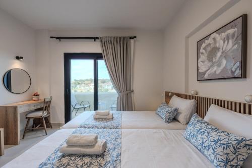 een slaapkamer met 2 bedden, een bureau en een raam bij Dina Villa in Roumelí